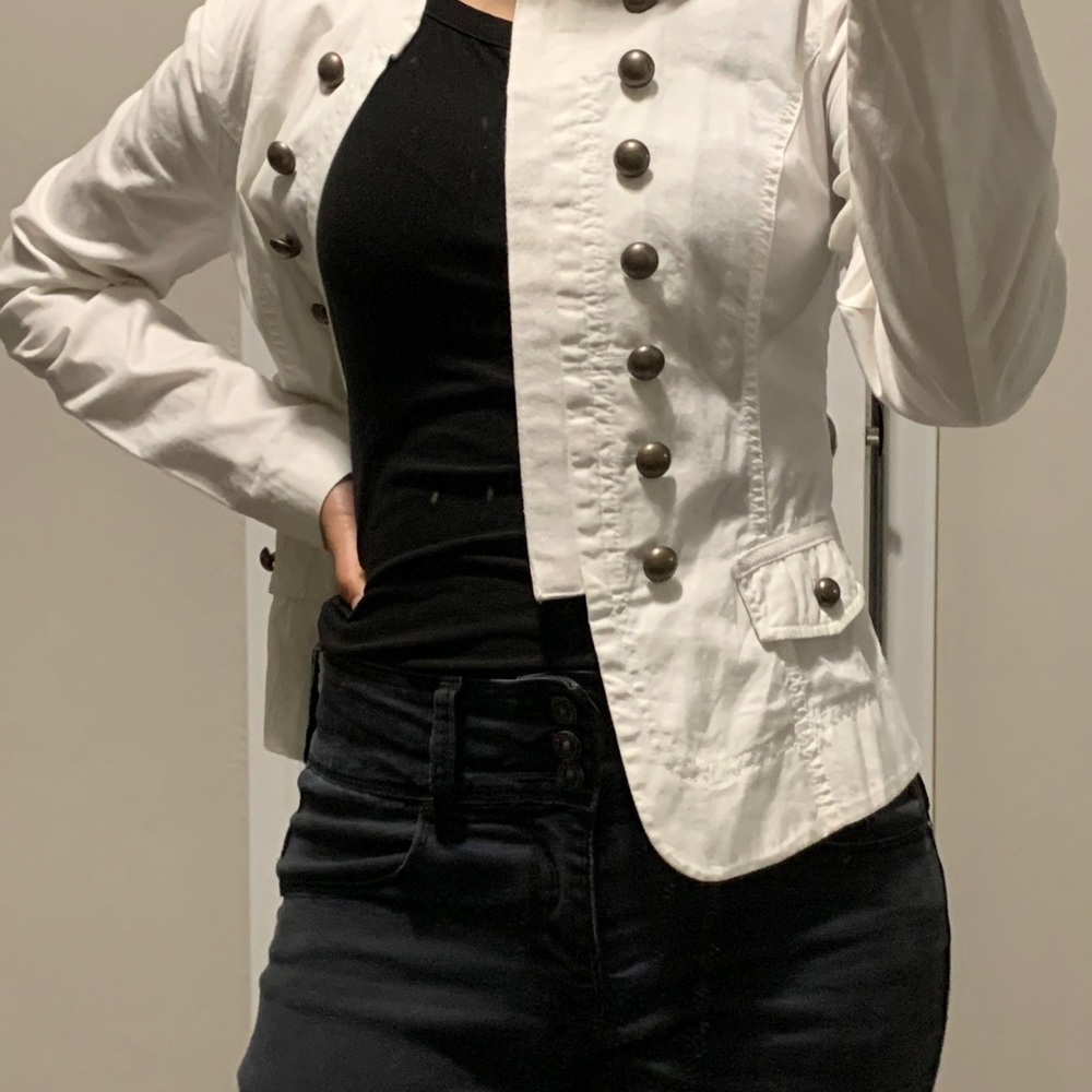 White blazer with black buttons.